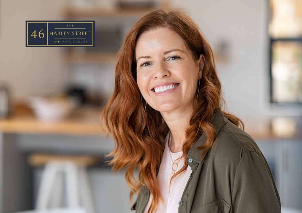 Person with red hair looking at the camera with a slightly tilted head whilst smiling.
