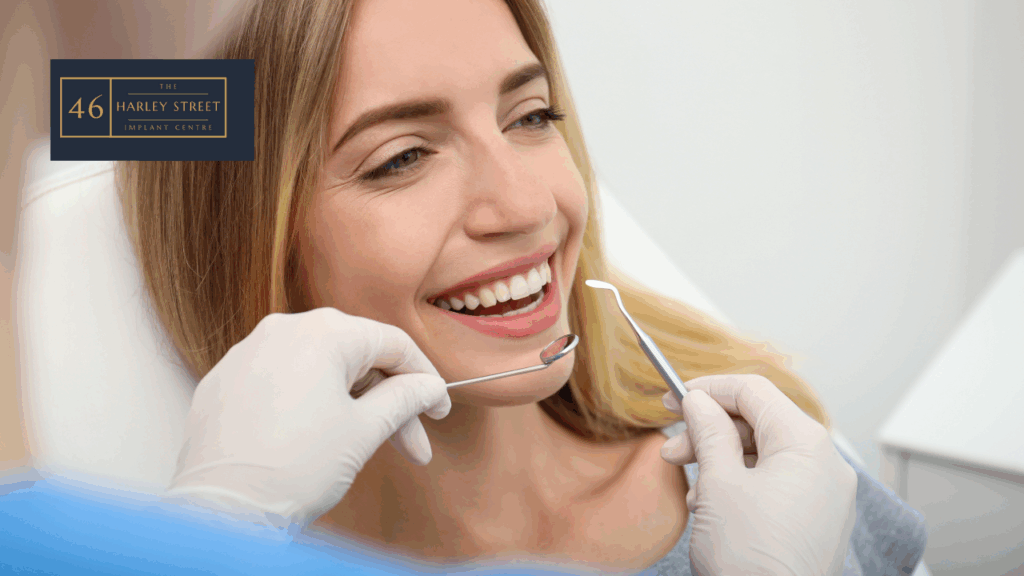 Person smiling on a dental chair looking forward as the dentist holds a dental mirror and another dental instrument.