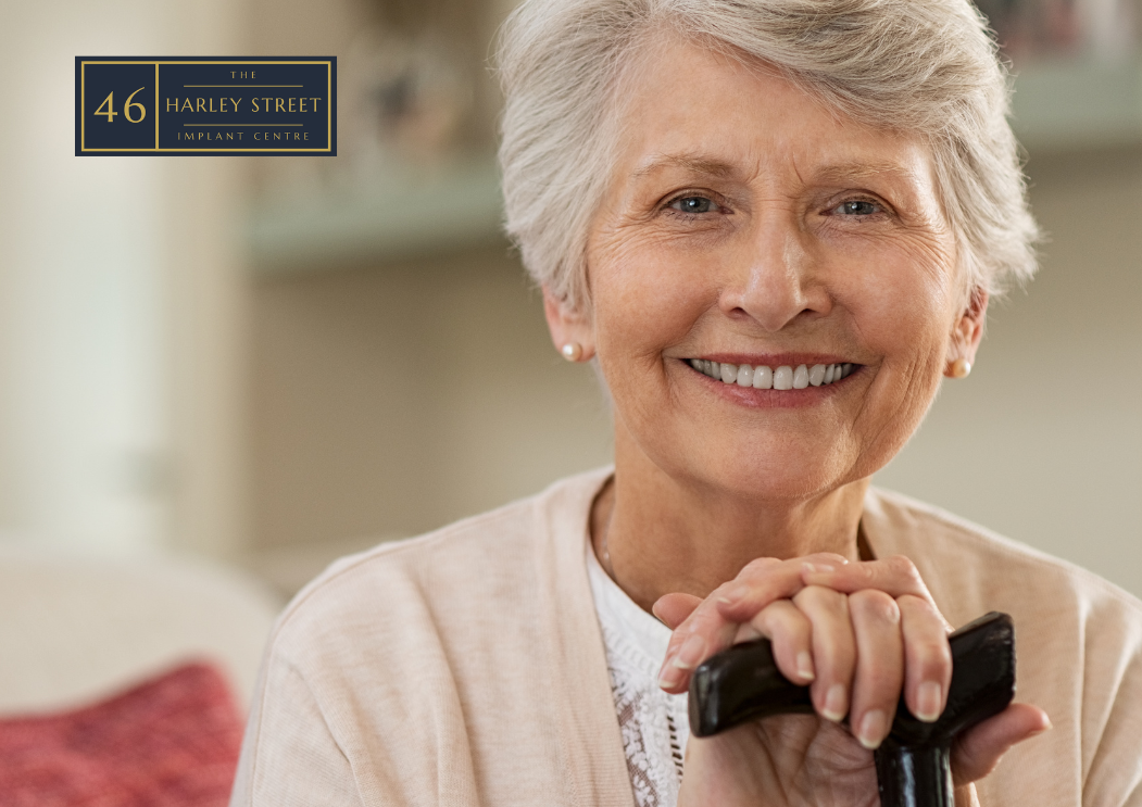 Person looking close into a camera holding a walking stick whilst smiling