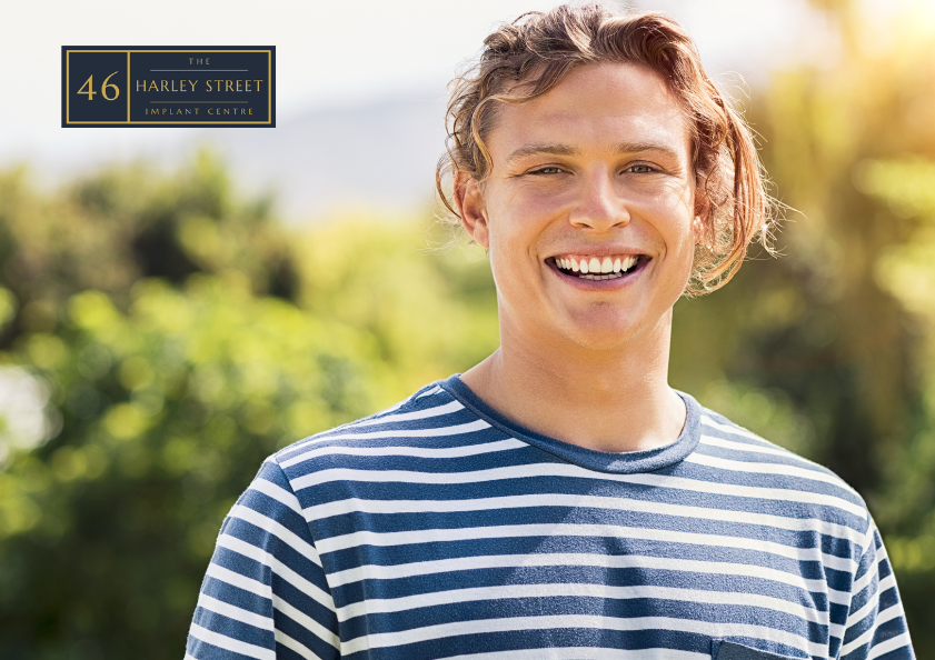 Person smiling in a green area looking directly at the camera.
