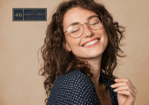 Person smiling with glasses on while slightly tilting their head