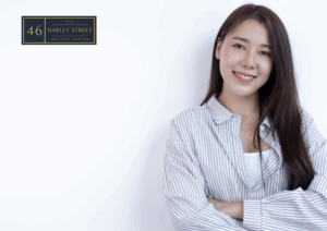 image of person leaning against white wall while smiling