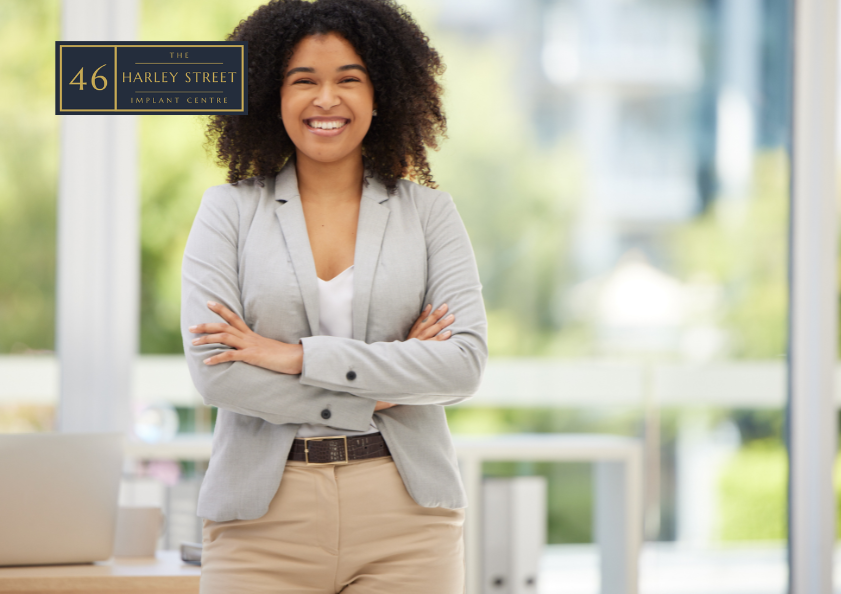 Image of person standing with arms crossed smiling into the camera
